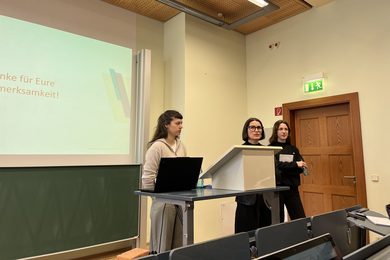 Drei Wissenschaftlerinnen halten einen Vortrag