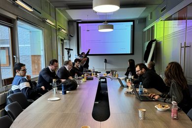 Teilnehmer:innen des Workshops sitzen zusammen an dem Tisch